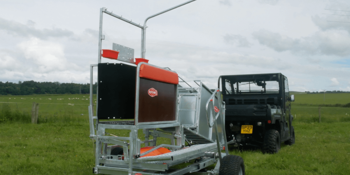 A tractor pulling a trailer in a green field, showcasing agricultural activity and rural landscape.